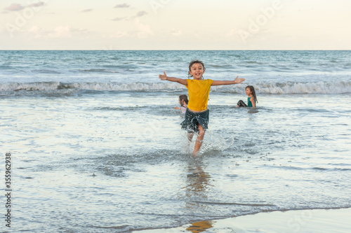 Child running in the water on the beach on a beautiful day