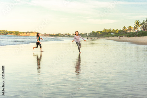 Children exercise running on the beach with drop shadow © Rogerio