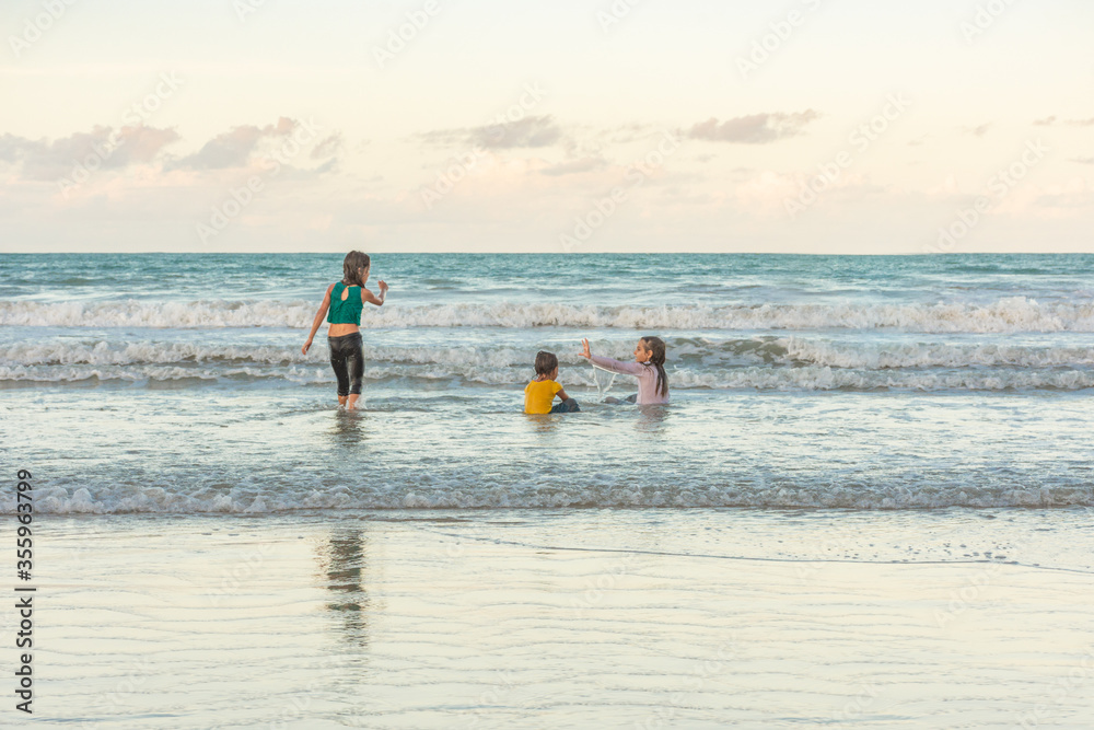 Children friends playing relaxed on the beach on a beautiful day