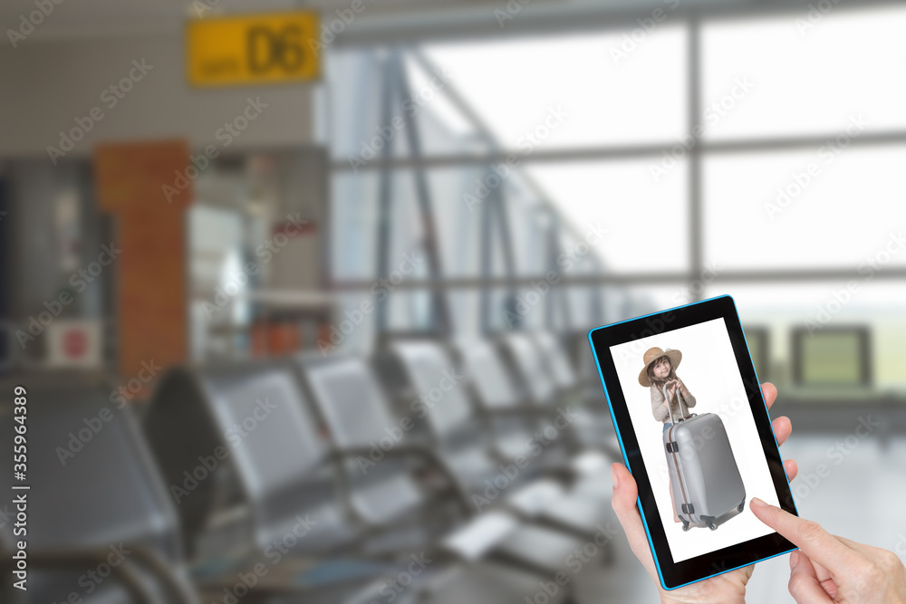 Hands holding tablet with little tourist girl on the screen in empty airport terminal interior. Hands holding tablet with little tourist girl on the screen in empty airport terminal interior.