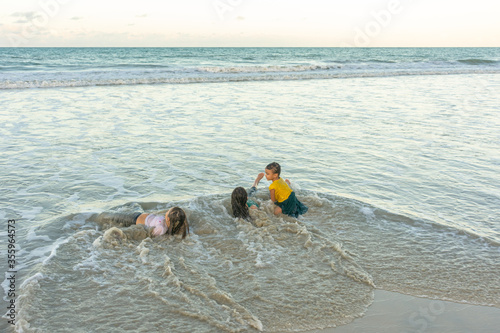 Children friends playing relaxed on the beach on a beautiful day