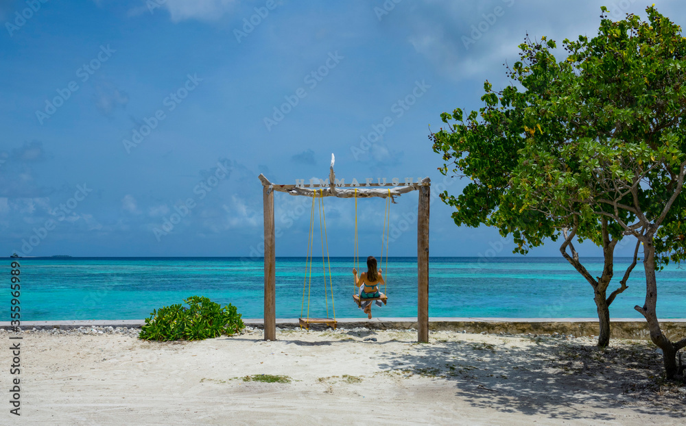 Unrecognizable female tourist swings and observes the gorgeous tropical beach Unrecognizable female tourist swings and observes the gorgeous tropical beach