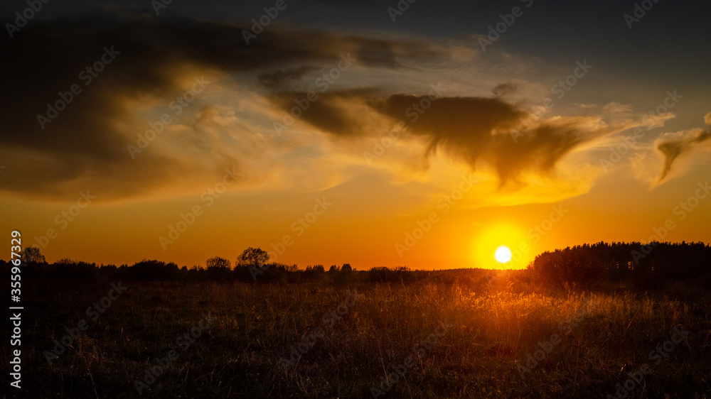 Beautiful sunset in the field. Dramatic sky. Evening sunset. Beautifully colored clouds at sunset.