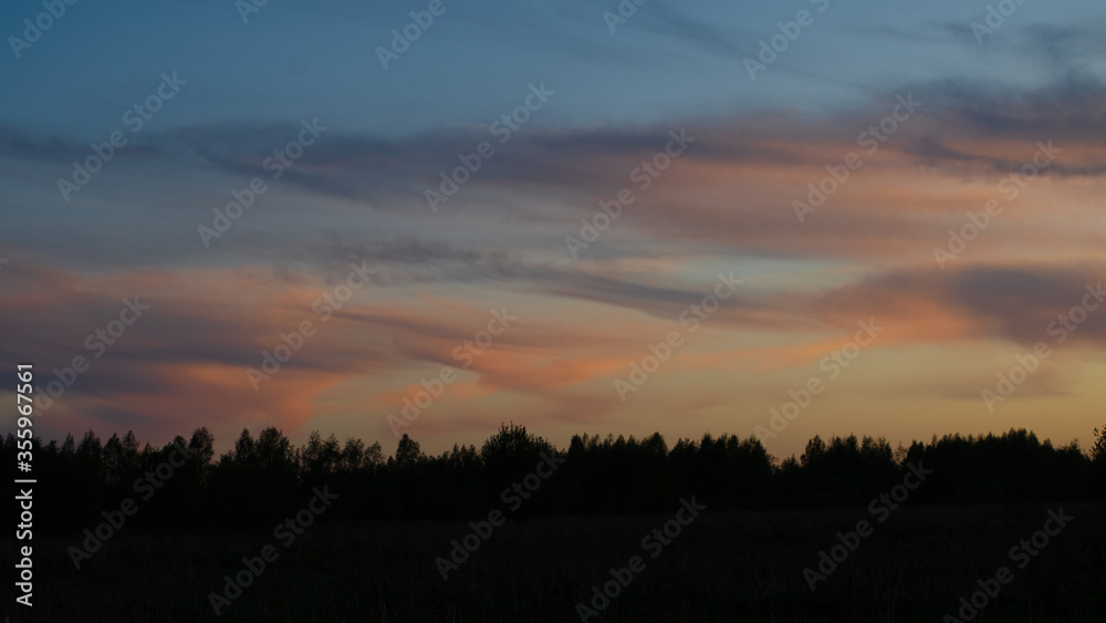 Beautiful sunset in the field. Dramatic sky. Evening sunset. Beautifully colored clouds at sunset.