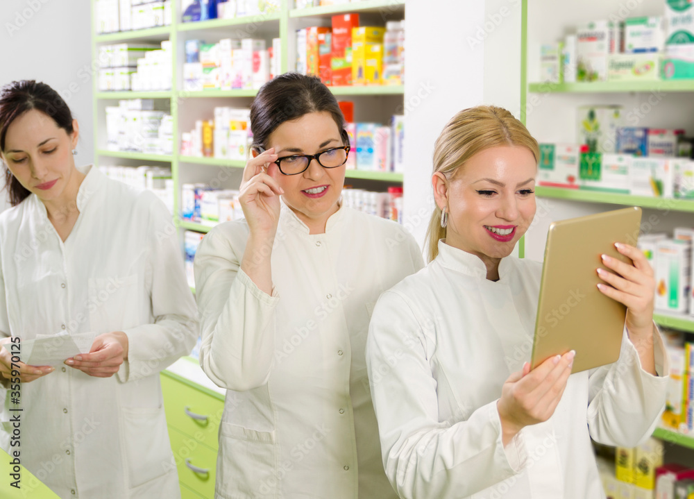 Three pharmacists working together, positive coworkers Three pharmacists working together, positive coworkers