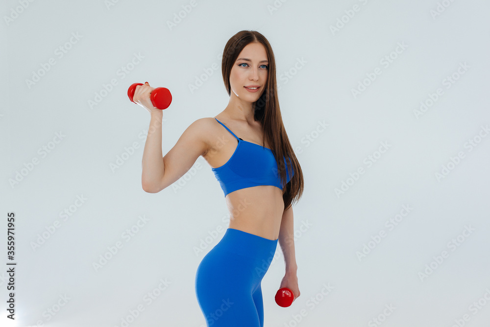 Sexy young girl performs sports exercises on a white background. Fitness, healthy lifestyle Sexy young girl performs sports exercises on a white background. Fitness, healthy lifestyle