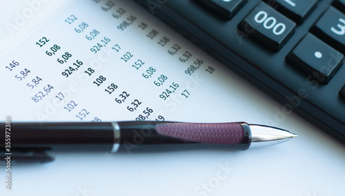 Image of pen and calculator on a document with numbers.