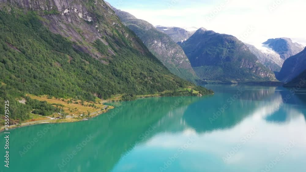 Aerial view on a blue lake with some houses on the beach. Landscape with a drone. Blue lakes, islands, and green forests from above on a cloudy summer morning Aerial view on a blue lake with some houses on the beach. Landscape with a drone. Blue lakes, islands, and green forests from above on a cloudy summer morning
