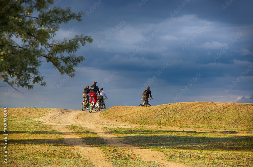 Bicycle tourism in the wild in the fields. Cycling for families. Sports and recreation for men and women to strengthen health and travel.