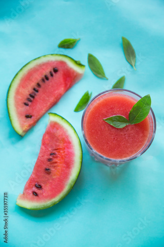 Fresh Watermelon Juice, Smoothie on Blue Background with Watermelon Slice and Mint Leaves, Top View