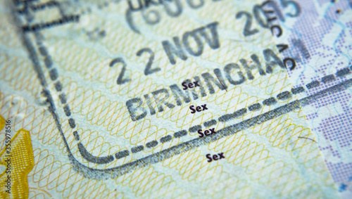 Entry stamp in passport made by immigration officer  at border and visa control at Birmingham airport in United Kingdom. Selective focus. Macro photo. © Ascannio