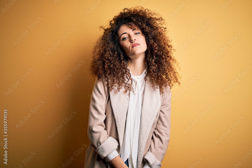 Young beautiful brunette woman with curly hair and piercing wearing casual t-shirt and diadem Relaxed with serious expression on face. Simple and natural looking at the camera. Young beautiful brunette woman with curly hair and piercing wearing casual t-shirt and diadem Relaxed with serious expression on face. Simple and natural looking at the camera.