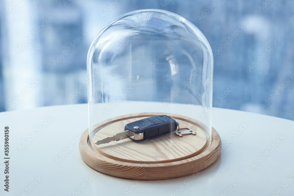Car key under glass cap. Symbol of car insurance or automobile safety... Car key under glass cap. Symbol of car insurance or automobile safety...