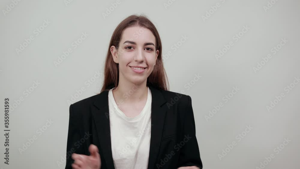 People clapping their hands during a meeting, congratulation and appreciation. Young attractive woman with brown hair in light t-shirt, black jacket on white background People clapping their hands during a meeting, congratulation and appreciation. Young attractive woman with brown hair in light t-shirt, black jacket on white background
