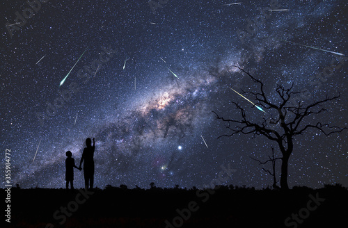 Dzieci obserwujące rój meteorów potocznie zwany deszczem spadających gwiazd, oraz piękna Droga Mleczna  z wyraźnie widocznym centrum naszej galaktyki - Children observing a swarm of meteors photo