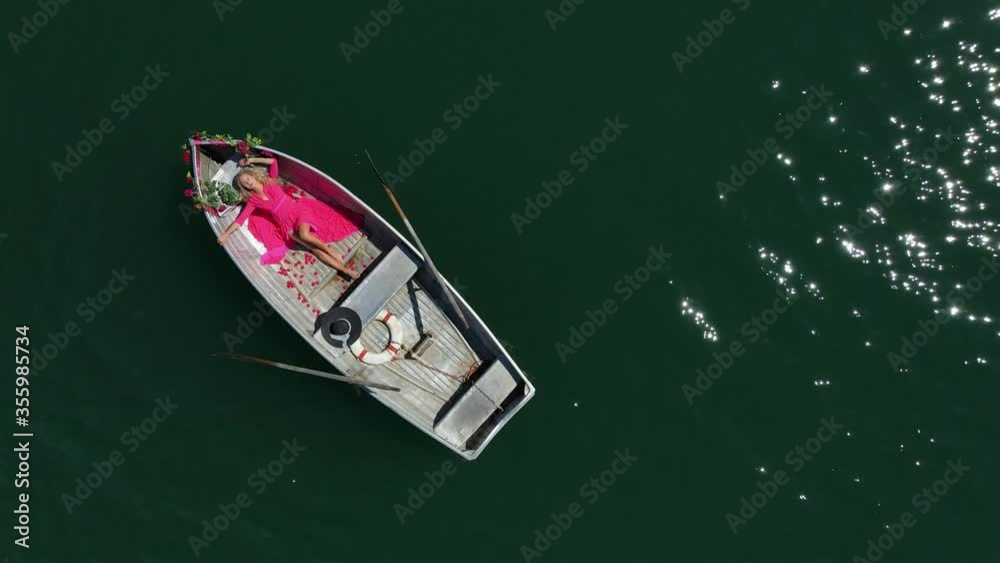 Happy beautiful woman floating in a boat after the marriage proposal. Romantic scene Happy beautiful woman floating in a boat after the marriage proposal. Romantic scene