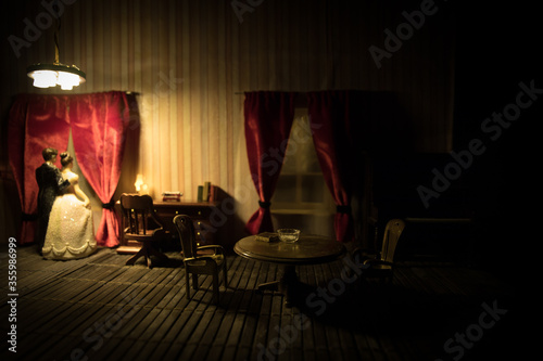 A realistic dollhouse living room with furniture and window at night. Artwork table decoration with handmade realistic dollhouse.