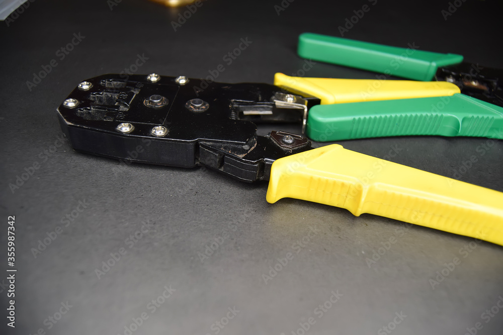 Fototapeta premium Yellow and green adjustable wire stripper isolated on a black background, Adjustable wire stripper isolated isolated a black background