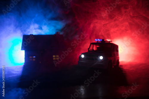 Police cars at night. Police car chasing a car at night with fog background. 911 Emergency response police car speeding to scene of crime. Selective focus