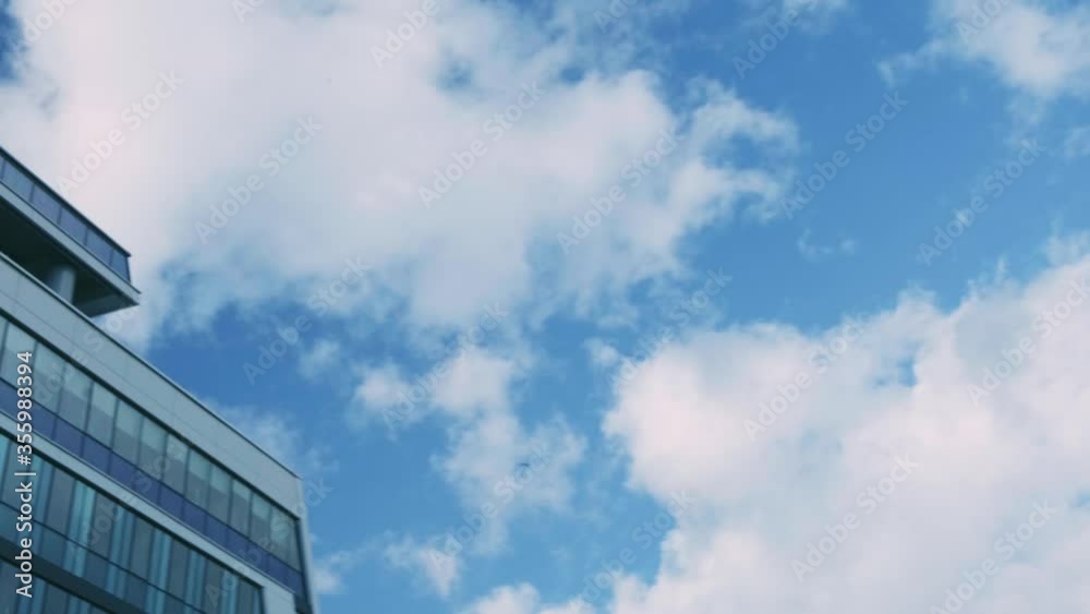 Smooth camera movement in front of office building windows reflecting sunny blue sky with white puffy clouds. Smooth camera movement in front of office building windows reflecting sunny blue sky with white puffy clouds.