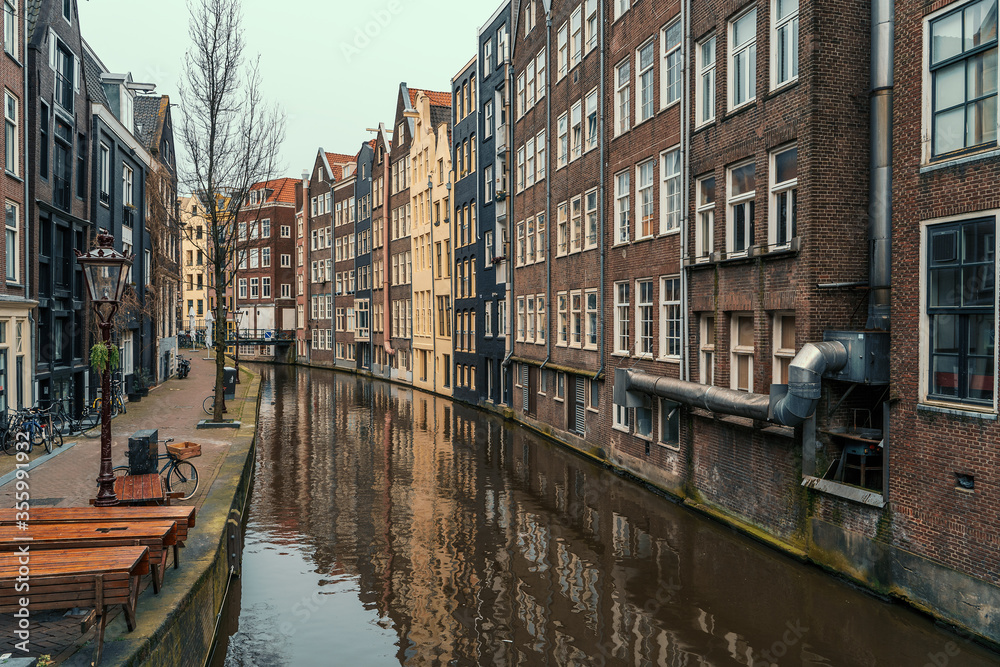 Typical famous water canal and dancing houses in empty Amsterdam downtown, Netherlands.