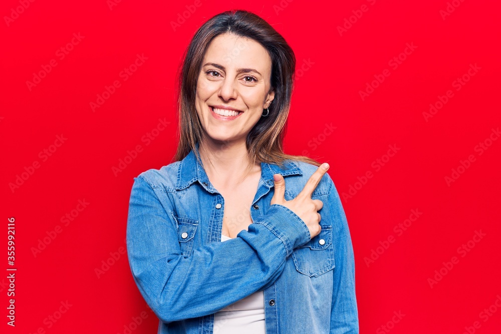 Young beautiful woman wearing casual clothes cheerful with a smile of face pointing with hand and finger up to the side with happy and natural expression on face Young beautiful woman wearing casual clothes cheerful with a smile of face pointing with hand and finger up to the side with happy and natural expression on face