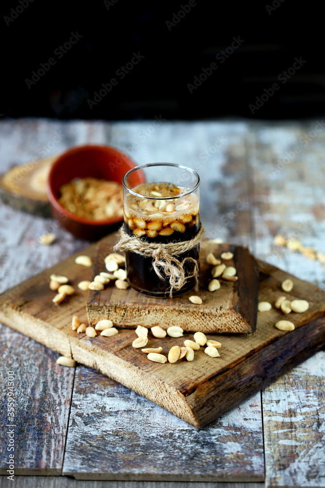 Selective focus. A glass of coca cola and peanuts. Salted peanuts in a