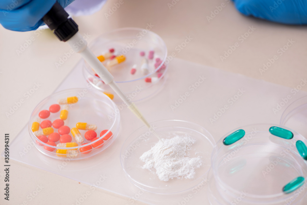 Young male lab assistant in drug synthesis concept