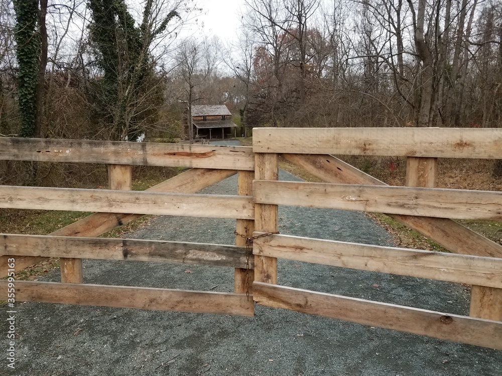 wood fence or gate and gravel road to house