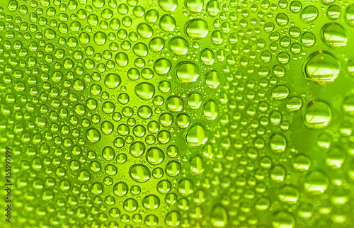 Close up water drops on light green tone background. Abstract sky light green wet texture with water drops on glass surface. 