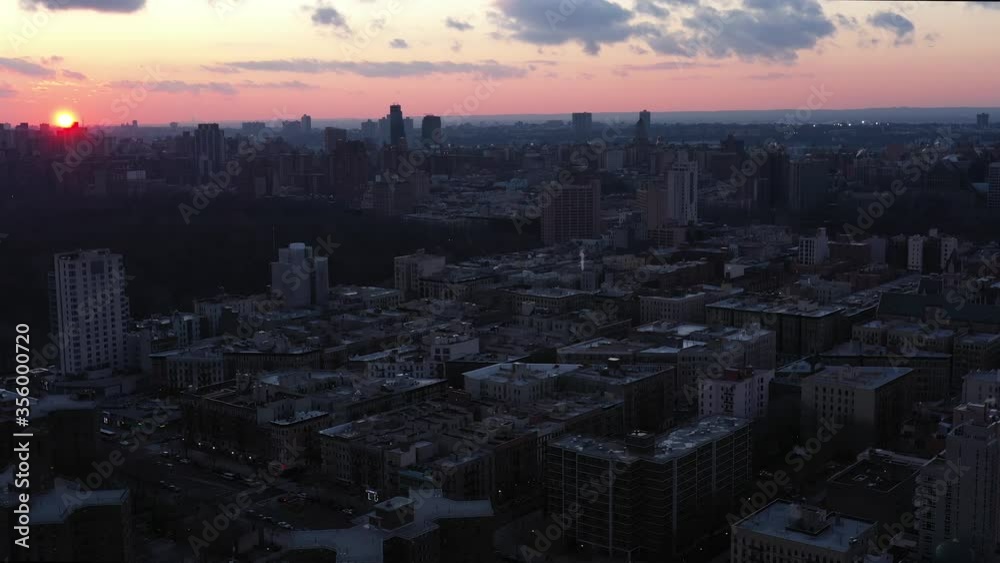 aerial flight over New York City's Harlem neighborhood with gorgeous setting sun and clouds visible. aerial flight over New York City's Harlem neighborhood with gorgeous setting sun and clouds visible.
