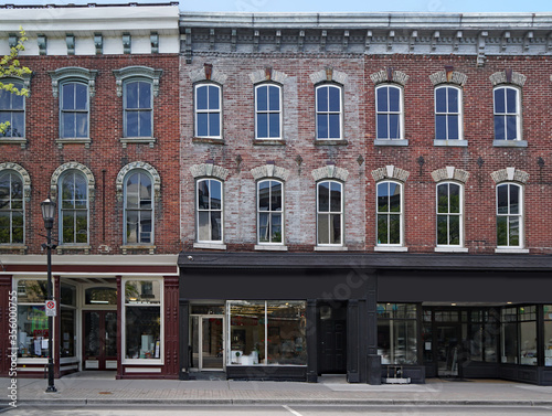 facade of old brick buildings with stores at street level and apartments above