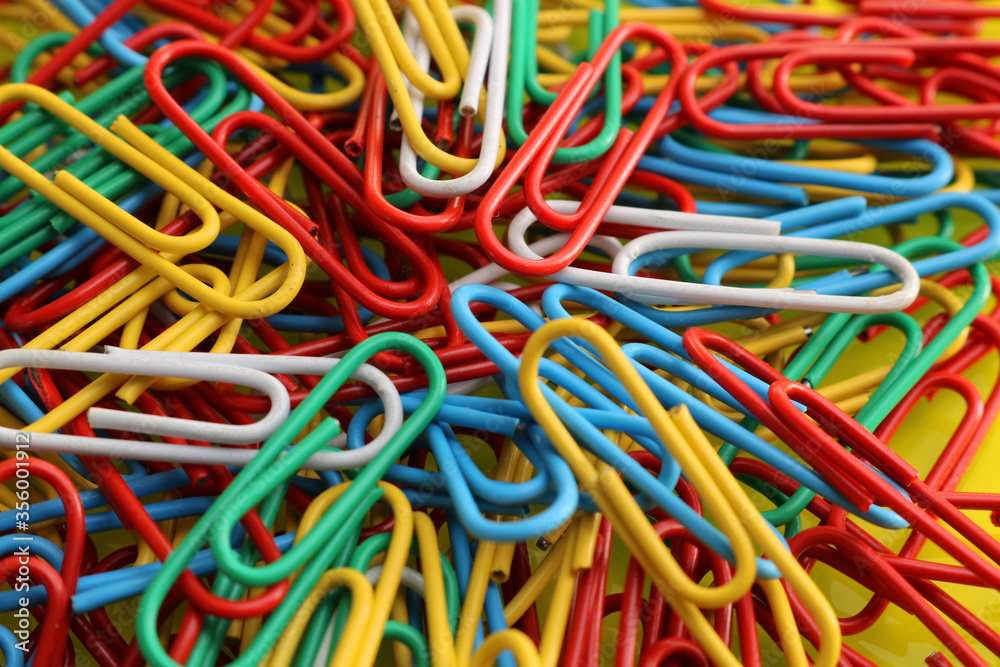 A pile of paperclips of different colours used in stationary to affix various pieces of paper together. A pile of paperclips of different colours used in stationary to affix various pieces of paper together.
