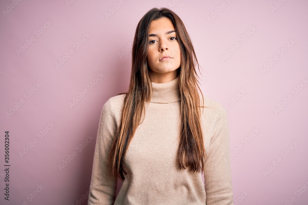 Obraz premium Young beautiful girl wearing casual turtleneck sweater standing over isolated pink background Relaxed with serious expression on face. Simple and natural looking at the camera.
