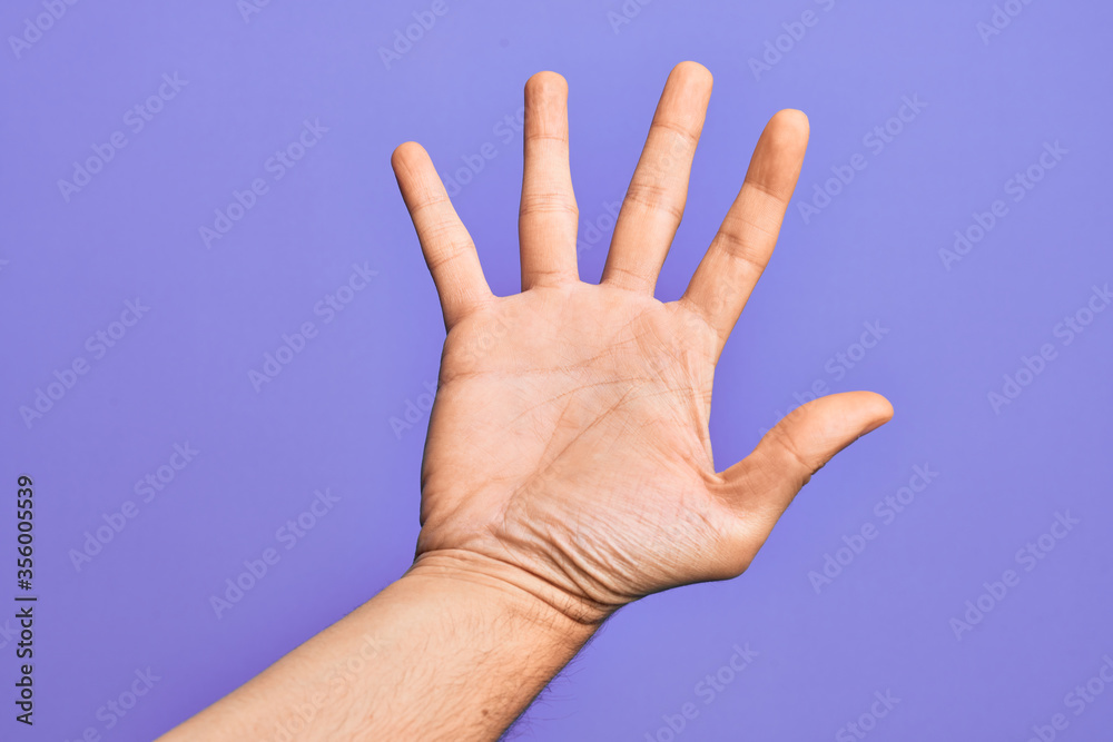 Hand of caucasian young man showing fingers over isolated purple background counting number 5 showing five fingers Hand of caucasian young man showing fingers over isolated purple background counting number 5 showing five fingers