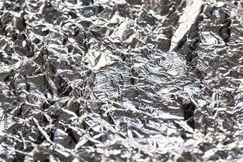 thin and crumpled shiny aluminum foil,