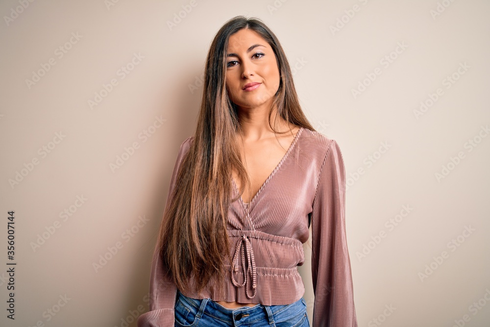 Young beautiful brunette elegant woman with long hair standing over isolated background Relaxed with serious expression on face. Simple and natural looking at the camera. Young beautiful brunette elegant woman with long hair standing over isolated background Relaxed with serious expression on face. Simple and natural looking at the camera.