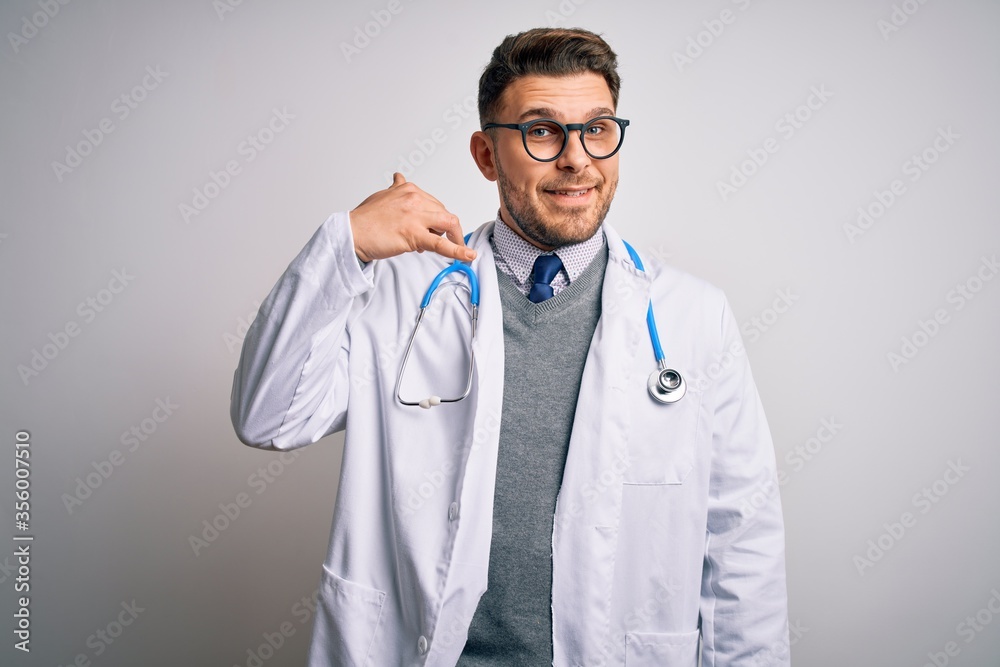 Young doctor man with blue eyes wearing medical coat and stethoscope over isolated background smiling doing phone gesture with hand and fingers like talking on the telephone. Communicating concepts. Young doctor man with blue eyes wearing medical coat and stethoscope over isolated background smiling doing phone gesture with hand and fingers like talking on the telephone. Communicating concepts.