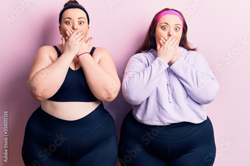 Young plus size twins wearing sportswear shocked covering mouth with hands for mistake. secret concept.