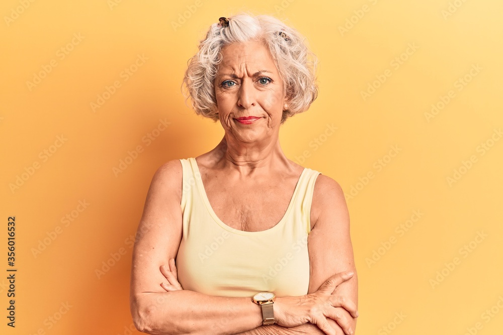 Senior grey-haired woman wearing casual clothes skeptic and nervous, disapproving expression on face with crossed arms. negative person. Senior grey-haired woman wearing casual clothes skeptic and nervous, disapproving expression on face with crossed arms. negative person.