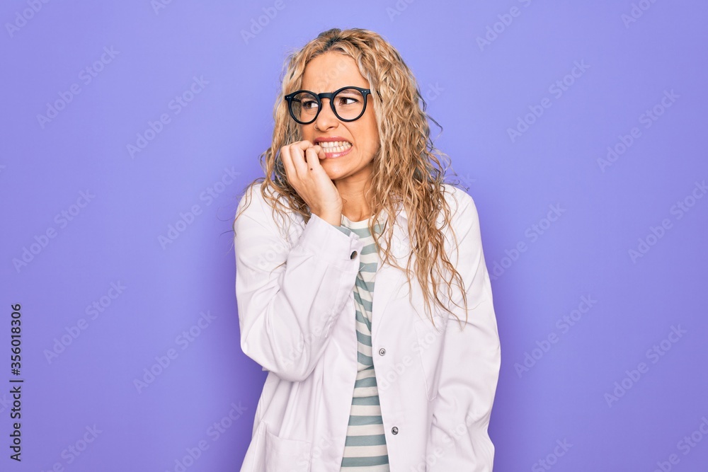 Young beautiful blonde scientist woman wearing coat and glasses over purple background looking stressed and nervous with hands on mouth biting nails. Anxiety problem.