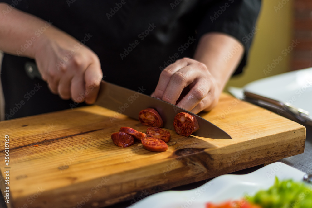 Cutting chorizo in the kitchen