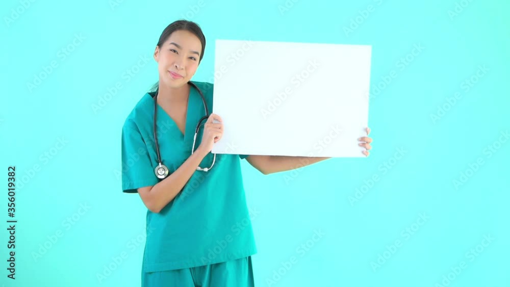 A young attractive medical professional in scrubs and a stethoscope around her neck, holds up a black card for your message. Copy space A young attractive medical professional in scrubs and a stethoscope around her neck, holds up a black card for your message. Copy space