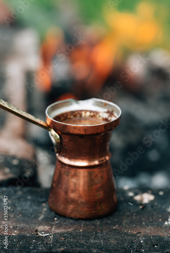 Hot coffee in turkish coffee pot isolated on bonfire and coal background