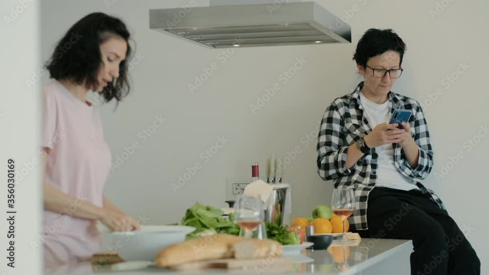 adult lesbian couple or female friends talk together give advice at kitchen Rbbro. woman browsing phone and girlfriend cooking healthy good salad, cutting vegetables. concept cozy, domestic, preparing adult lesbian couple or female friends talk together give advice at kitchen Rbbro. woman browsing phone and girlfriend cooking healthy good salad, cutting vegetables. concept cozy, domestic, preparing