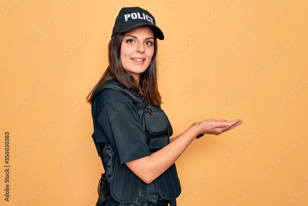 Φωτογραφία Young beautiful brunette policewoman wearing police uniform bulletproof and cap