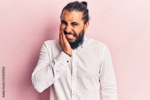 Young arab man wearing casual clothes touching mouth with hand with painful expression because of toothache or dental illness on teeth. dentist