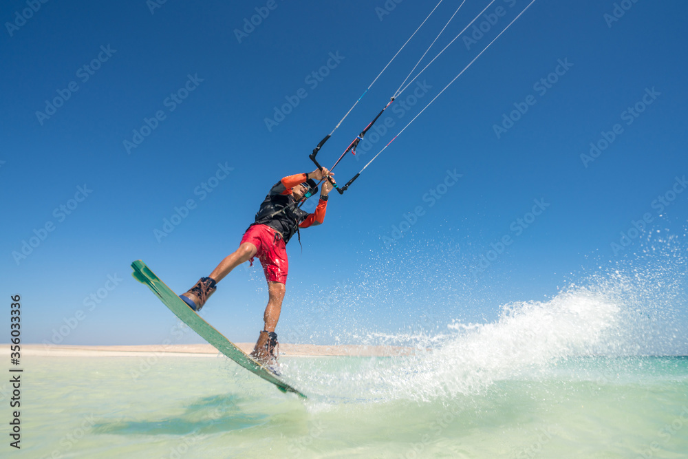 kiter does a difficult trick on a background of transparent water and blue sky kiter does a difficult trick on a background of transparent water and blue sky