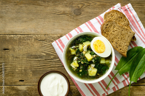 Green borsch with sorrel and eggs on a wooden background
