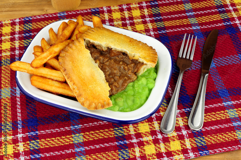 Valokuva Steak and kidney pie and chips meal with mushy peas in a metal enamel dish